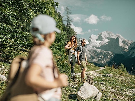 Eltern mit Ihrer Tochter am Wanderweg im Salzkammergut mit Bergpanorama