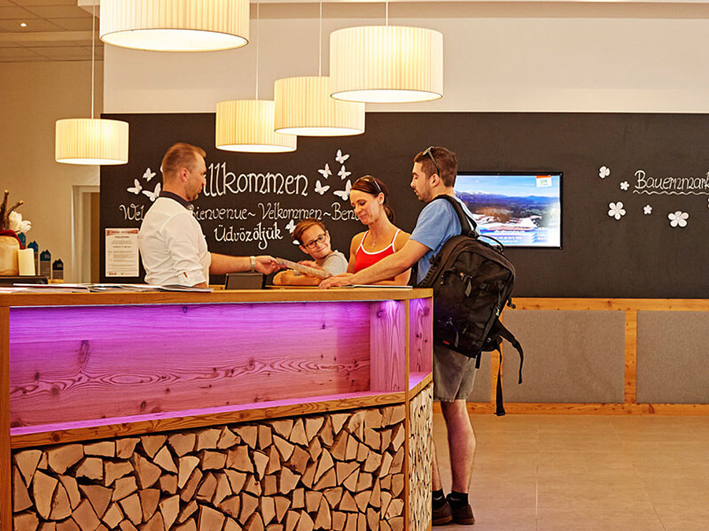 Anmeldung an der Rezeption im COOEE alpin Hotel Dachstein in Gosau