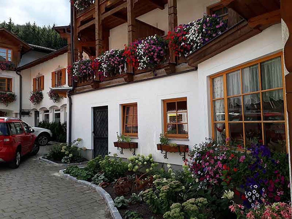 Gebäude mit Balkonblumen des Hotel Sperlhof in Windischgarsten