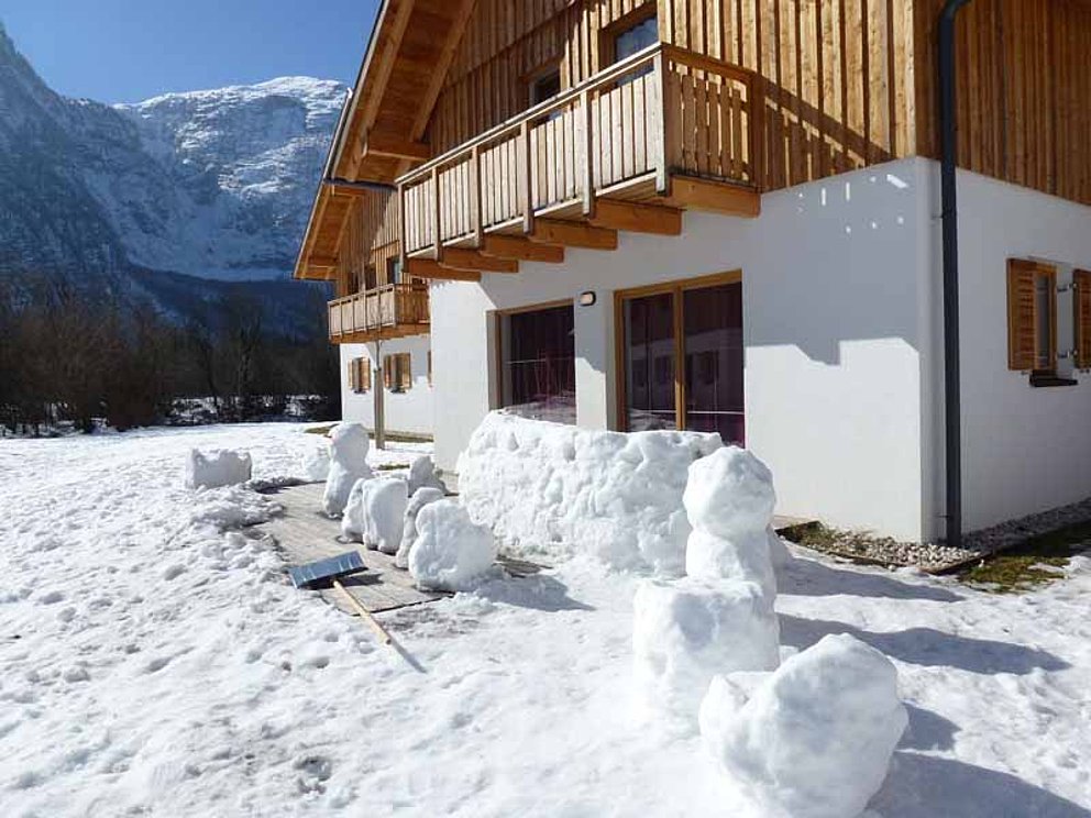 Schneemänner vor einem Ferienhaus