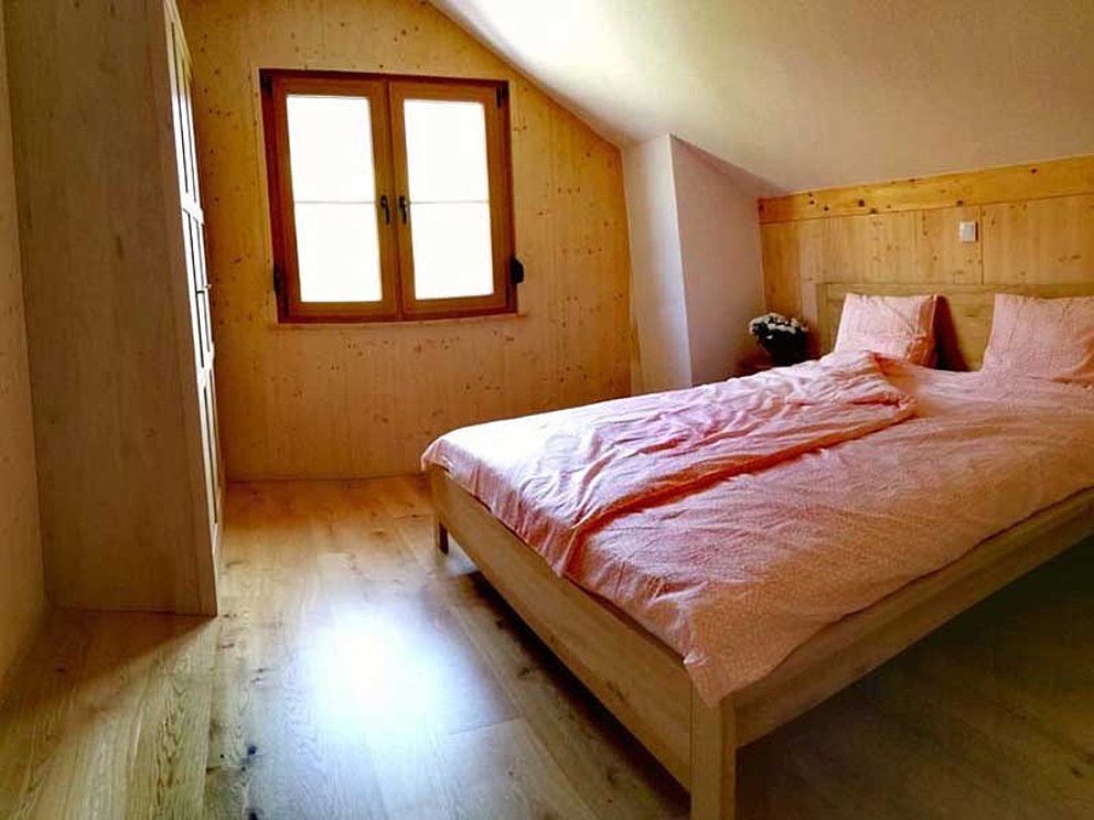 Blick in ein Schlafzimmer mit Doppelbett im Ferienresort Altaussee