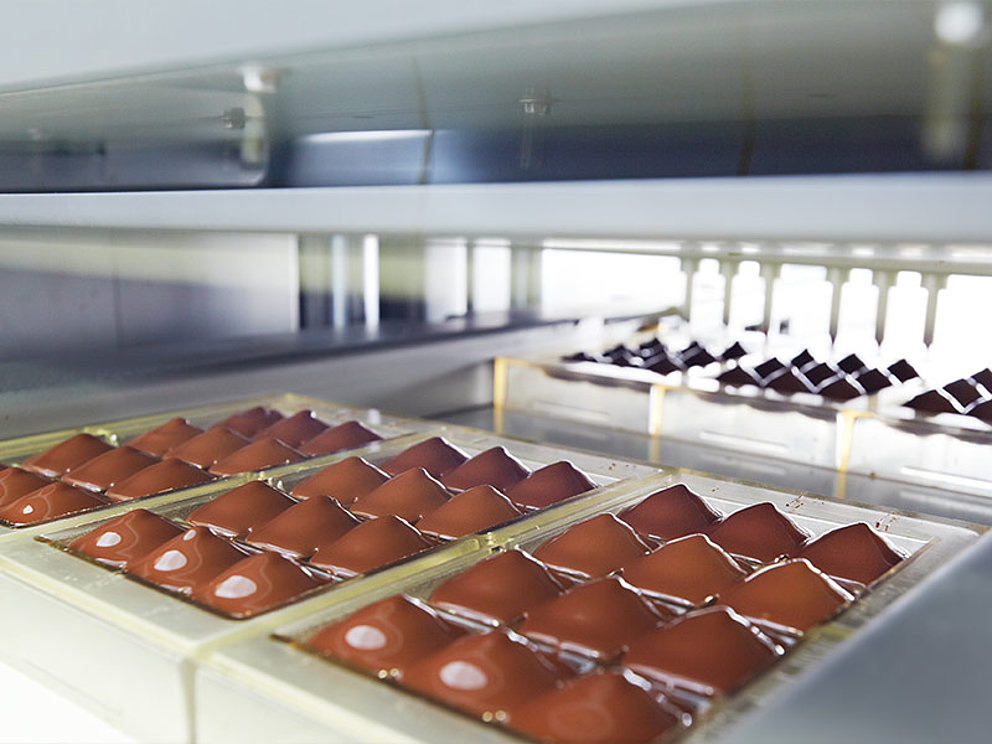 Schokolade wird in Tafel-Rohlinge gefüllt