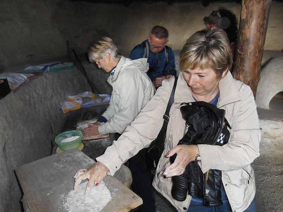 Frauen backen Brot wie zu Zeiten der Kelten im Keltendorf Mitterkirchen