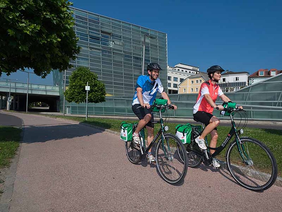 Zwei Radfahrer unterwegs am Donauradweg vorbei an Linz
