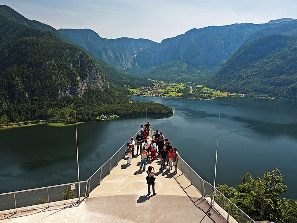 Menschen auf einer Plattform, im Hintergrund der Hallstätter See und Berge