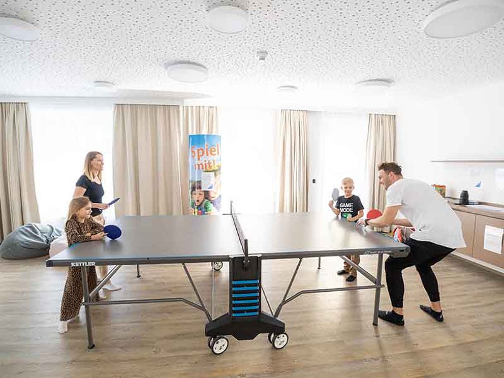 Eltern mit Kindern spielen Tischtennis 