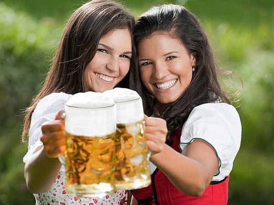 2 fesche Mädels stemmen je eine Mass Bier