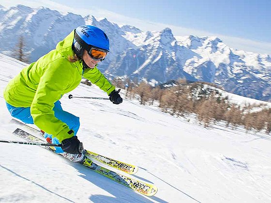 Frau mit grüner Jacke beim Skifahren in der Skiregion Hinterstoder-Wurzeralm