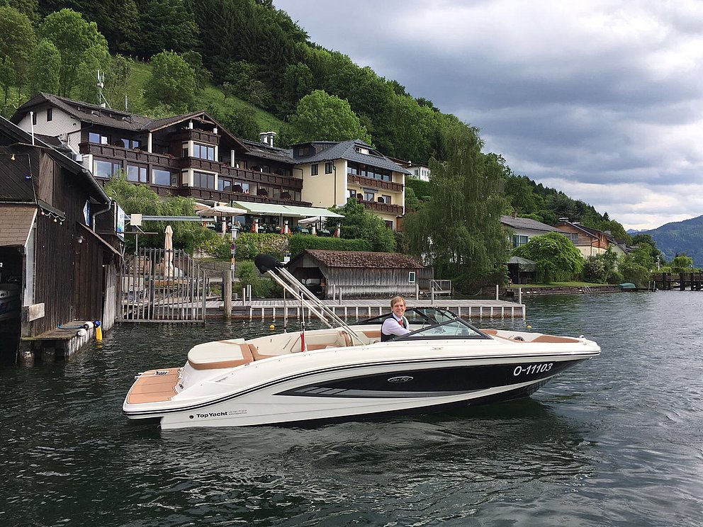 Motorboot am Traunsee, im Hintergrund das Hotel Grünberg am See