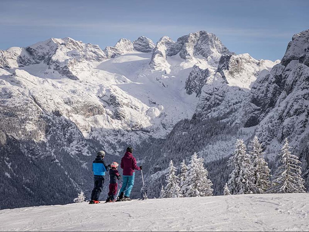 3 Skifahrer von Hinten, im Hintergrund der Dachstein