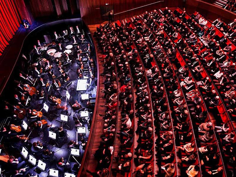 Blick auf vollen Saal im Musiktheater Linz mit Orchester