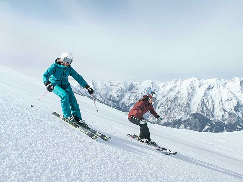 zwei Skifahrerinnen auf der Abfahrt im Skigebiet Hinterstoder und Wurzeralm