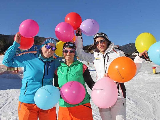 Drei Skifahrerinnen mit bunten Luftballons in der Gaudiwoche in der Skiregion Dachstein West