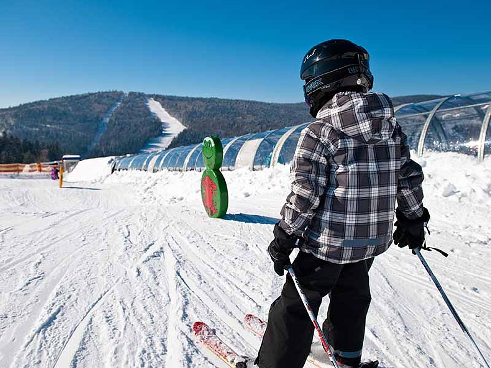 Kind beim Skifahren auf der Kinderskiwiese im Skigebiet Hochficht
