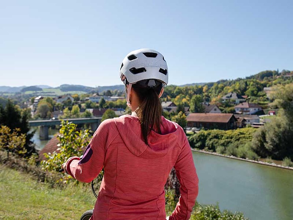 junge Frau blickt auf den Fluss Steyr in idyllischer Natur