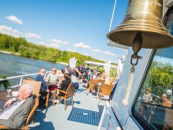 Sommerliches Freideck mit Bordglocke im Vordergrund