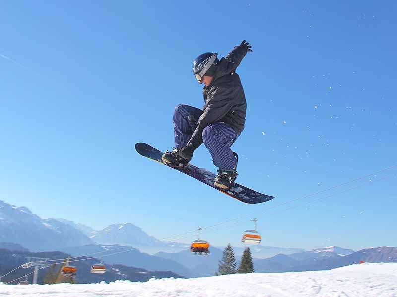 Snowboarder beim Springen in der Skiregion Dachstein West